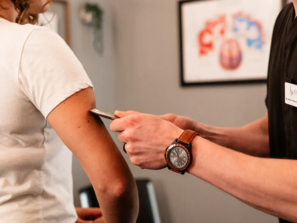 Instrument-assisted soft tissue work on a patient's arm